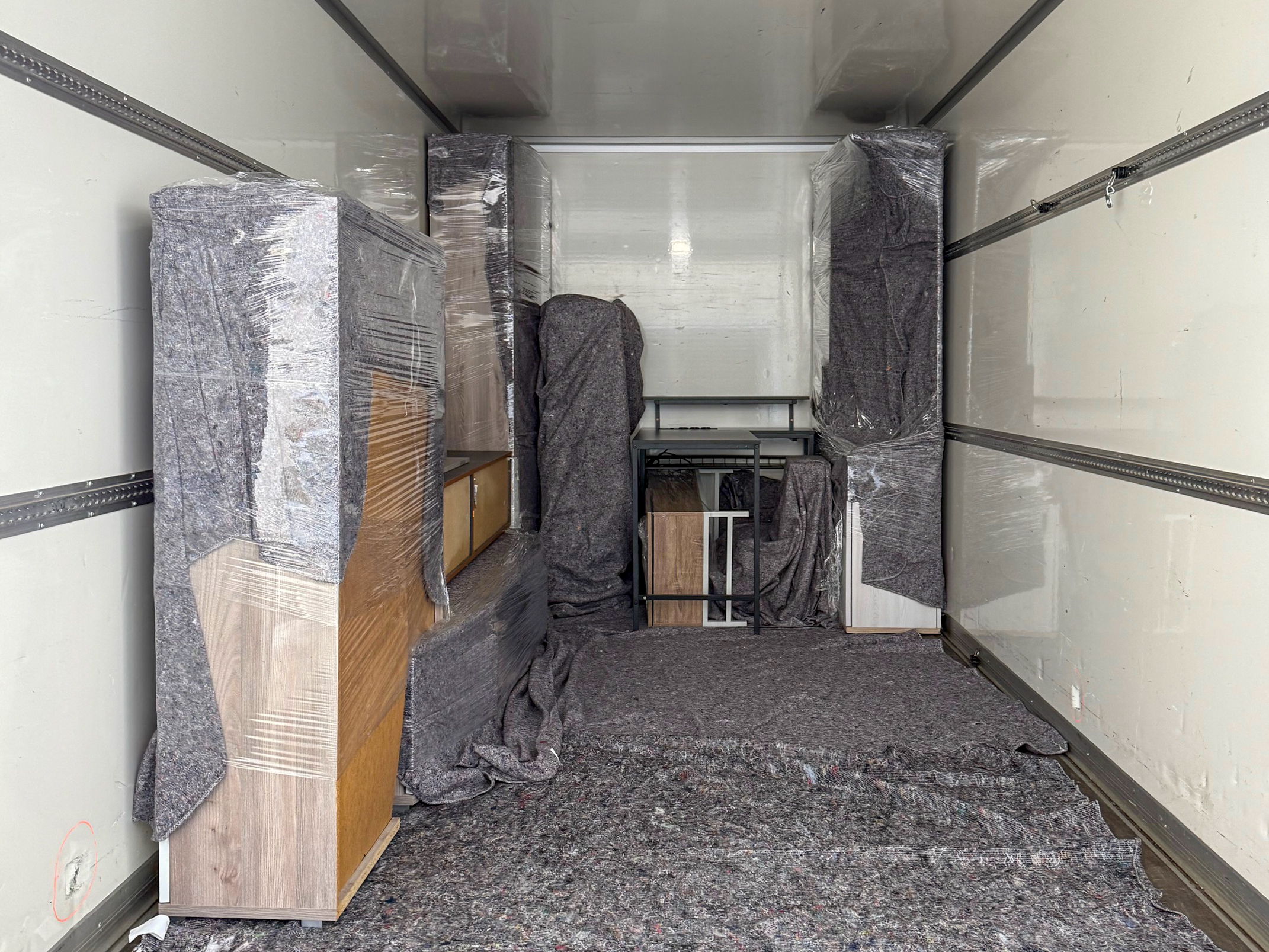 Möbel mit Umzugsdecken und Schutzfolie im Laderaum eines Umzugswagens – professioneller Umzug in Lübeck